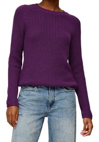 Fialový pletený svetr se žebrovanou texturou, kulatým výstřihem a dlouhými rukávy. Kombinován s roztrhanými světle modrými džíny.
