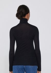 Schwarzes, langärmliges Rollkragenoberteil mit taillierter Passform, aus einem leichten Stoff gefertigt, mit glatter Textur und minimalistischen Stil.