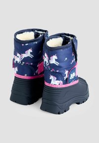 Kinderwaterdichte laarzen met een marineblauwe stof met eenhoorns en bloemenpatronen, roze accenten en zwarte rubberen zolen. Verkocht door JoJo.