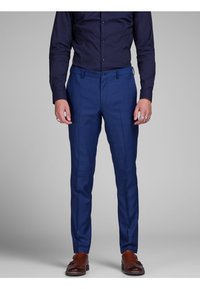 Blue tailored trousers with a smooth texture. Features a flat front, belt loops, and a slim fit design. Paired with brown leather shoes.
