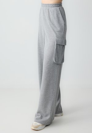 Pantalon de jogging gris en tissu doux, avec une taille élastique, des poches latérales et une grande poche cargo sur la cuisse.