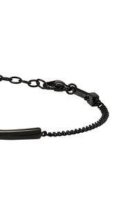 Černý řetízek s hladkým a lesklým ozdobným pruhem. Má propojené články, karabinu a na řetízku je zkroucená textura.