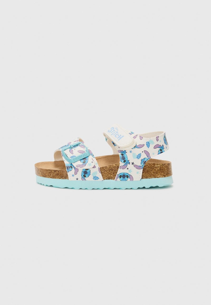 Sandales blanches avec un motif de dessin animé et des accents bleus, semelle en liège, boucle ajustable et semelle turquoise texturée.