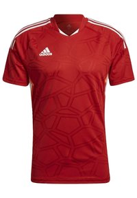 Czerwona koszulka sportowa z geometrycznym wzorem, w dekolcie w kształcie litery V, z trzema białymi paskami na każdym ramieniu. Wykonana z oddychającego materiału.