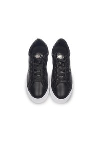 Baskets en cuir noir avec semelles en caoutchouc blanc, dotées de lacets plats noirs, d'une tige texturée et de détails du logo de la marque sur la languette.