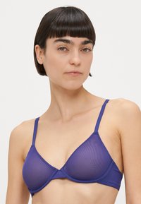 Lilla rinnahoidja kolmnurksete tassi, õhukeste reguleeritavate rihmade ja sileda tekstuuriga. Omab lihtsat disaini ja ei sisalda nähtavaid metalldetailid.