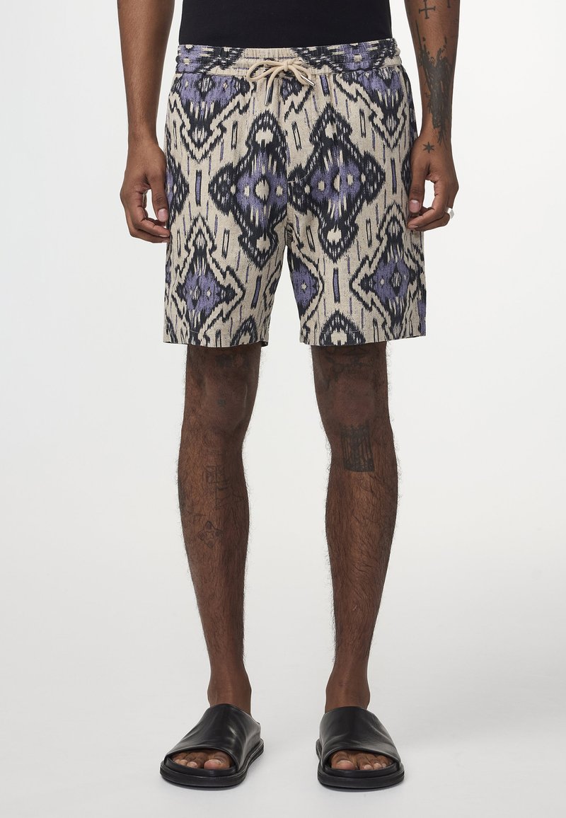 Mönstrade badshorts i beige, med en geometrisk design i lila och svart, försedd med dragsko i midjan och en avslappnad passform.