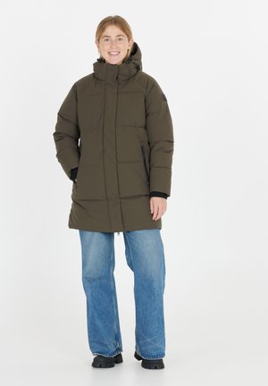 Puffjakke i mørkeoliven med quiltet design, høj krave, sidelommer og en mellemlang længde, parret med brede blå jeans.