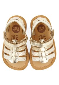 Gouden metallic sandalen met kruislingse bandjes, gemaakt van leer, met een platte zool en een tan kleurige inlegzool. Voorzien van een verstelbare gespsluiting voor een goede pasvorm.
