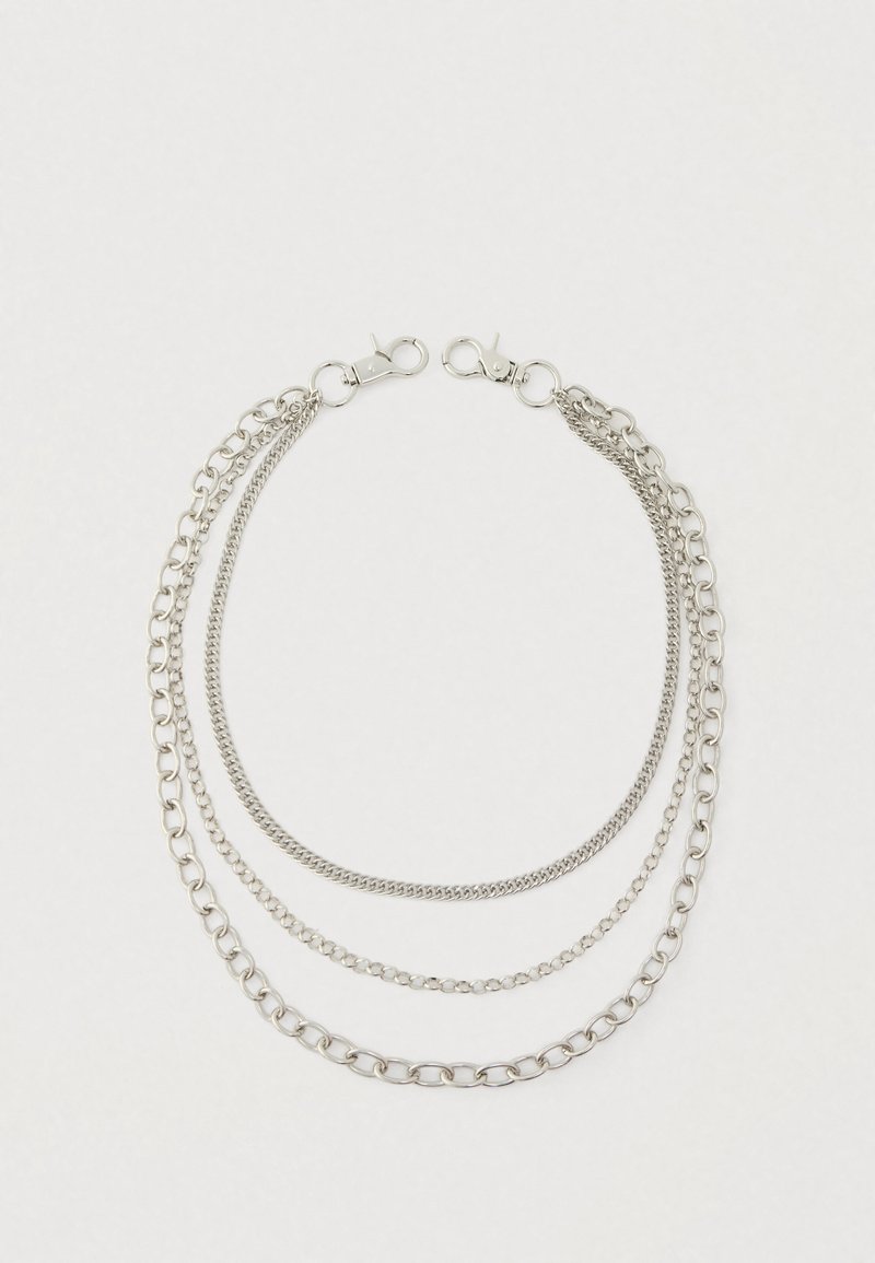 Zilveren ketting met drie lagen, die verschillende schakels en afwerkingen toont. Elke uiteinde heeft een karabijnsluiting voor veilige sluiting.