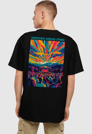 Black t-shirt featuring a vibrant, multicolored graphic of a concert scene with the text "Dancing Under Stars" at the top.