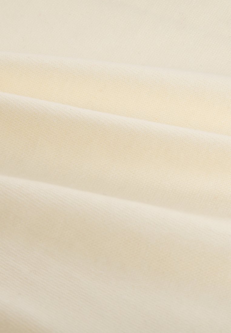 Weiches, cremefarbenes Gewebe mit sanften diagonalen Falten und einer glatten, fein gewebten Textur.