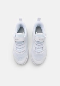 Scarpe sportive bianche con parte superiore in rete, design con lacci, cinturino in velcro e un piccolo logo argento. Presentano una punta arrotondata e una suola ammortizzata.