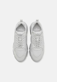 Witte leren sneakers met een ronde neus, afgeronde randen, platte veters en een gestructureerde zool. Kenmerken zijn onder andere een reliëf logo op de tong.