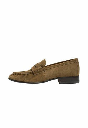 Brun ruskindslipper med lav sort hæl og en klassisk remdetalje over toppen.