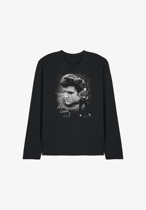 Black long-sleeve shirt featuring two black-and-white images of Elvis Presley, one close-up portrait and one full-body in a sweater and sneakers.
