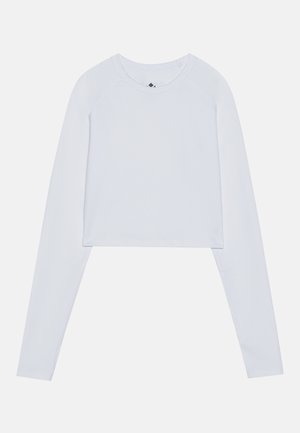 Kortermet langermet topp i ensfarget hvit, laget av myk stoff, med rund hals og raglanermet design uten synlig maskinvare.