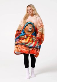 Kapuce ar brūna vāveres attēlu, spilgtas krāsas mīkstā, plīša tekstūrā; liels un vaļīgs dizains, kas piemērots komfortam un siltumam.