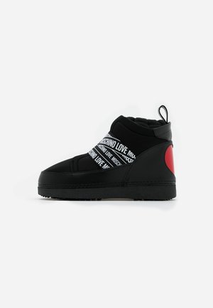 Baskets montantes noires avec des bandes blanches "LOVE MOSCHINO" à l'avant et un détail cœur rouge au talon, vue de côté.