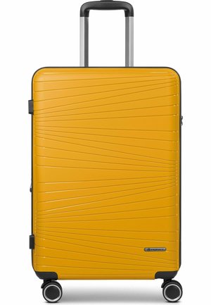 Valise rigide jaune avec des bordures noires, des lignes diagonales texturées, quatre roues pivotantes et une poignée télescopique déployée.