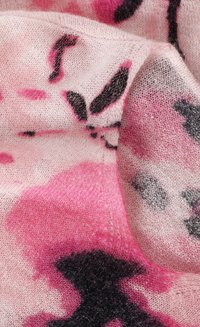 Strickstoff in rosa Tönen mit schwarzen und dunkleren rosa abstrakten Mustern. Weiche Textur mit leichtem Finish, das eine geringe Transparenz zeigt.