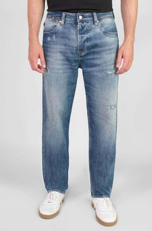 Blauwe denim jeans met een recht model, voorzien van een vervaagde was, subtiele wassing en twee voorzakken, gedragen met witte sneakers.