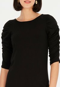 Czarna bluzka z rękawami do trzy czwarte, z marszczonymi detalami oraz szerokim dekoltem. Wykonana z gładkiej tkaniny z lekkim stretch'em.