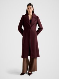 Burgundy wool coat with a notched collar, single button closure, and two side pockets, paired with brown wide-leg pants and pointy-toed heels.