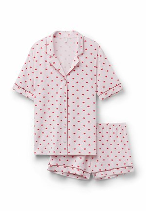 Světle růžové krátké pyžamové tričko s knoflíky a elastické šortky v pase, obě s drobným potiskem červených srdcí a červeným lemováním.