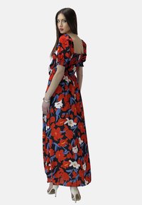 Abito maxi in tessuto nero con un vivace motivo floreale rosso e bianco, maniche a palloncino corte e schiena smock.