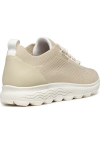 Sneaker beige con tomaia in tessuto intrecciato, sovrapposizione morbida sul tallone, intersuola testurizzata e suola flessibile con motivo a onda.
