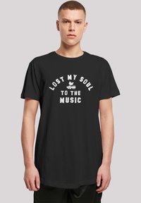 Black cotton t-shirt with short sleeves, featuring white text that reads "LOST MY SOUL TO THE MUSIC" and a graphic design below it.