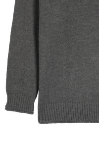 Szary sweter dzianinowy z luźnym krojem, prążkowanymi mankietami i dołem. Tekstura jest miękka, a wzór dzianiny jednolity i drobny.