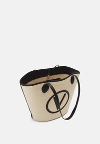 Toteväska i krämfärgad vävd tyg med svarta läderdetaljer. Har två handtag och en stor svart logotyp på framsidan. Öppen toppdesign.