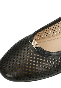 Černé perforované kožené ploché boty s kulatou špičkou, se zlato lesklým detailem vpředu. Měkká podšívka pro pohodlí.