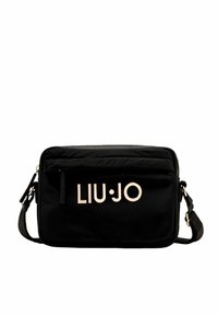 La borsa a tracolla nera in nylon presenta una chiusura in zip, una tracolla regolabile e un accento in metallo del logo. Ha una forma rettangolare semplice con una texture liscia.
