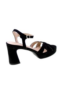 Sandalini neri in suede con tacco a blocco, dotati di cinturini incrociati e una cinghia alla caviglia con fibbia. Texture liscia e design con punta aperta.