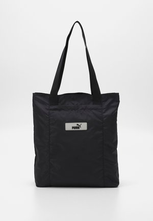 Czarna torba typu tote marki Puma z dwoma długimi rączkami i naszywką z logo z przodu, wykonana z gładkiego, lekko błyszczącego materiału.