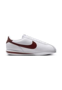 White athletic shoe with a textured leather upper, featuring a red swoosh logo, flat laces, and a slim rubber sole.