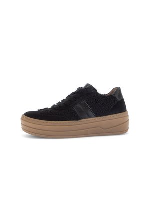 Black sneaker with a textured upper, suede and faux fur materials, lace-up design, and a thick, tan rubber sole. Features black leather accents.
