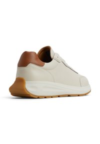 Baskets beige clair avec une tige en cuir texturé et un accent en cuir marron au niveau du talon, dotées d'un intermédiaire en caoutchouc blanc et d'une semelle extérieure en caoutchouc couleur caramel.