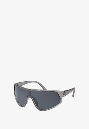 Päikeseprillid hallika tooniga läätsedega, siledad metallraamid, ümberkaudne disain ja minimalistlikud sangaosad.