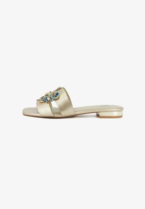Sandalo flat gold con ampie fasce e decorazione floreale blu tempestata di gioielli sulla parte superiore, tacco basso a blocco e design open toe.