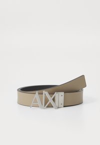 Beige öv sima felülettel és ezüst színű fém csattal, amelyen "AX" minta látható. Az öv elegáns, minimalista formájú.