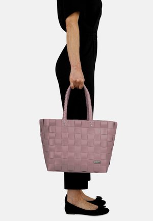 Woven pink tote bag with two handles, featuring metallic accents and a rectangular shape. Smooth texture with a checkered pattern.