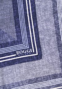 Tejido a rayas azul y blanco con patrones rectangulares concéntricos y el texto "BOGGI Milano" en la esquina inferior.