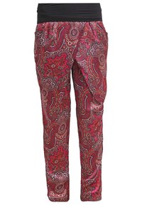 Röda och lila mönstrade byxor med ett svart midjeband. Tyget har paisleymönster och fickor på båda sidor.