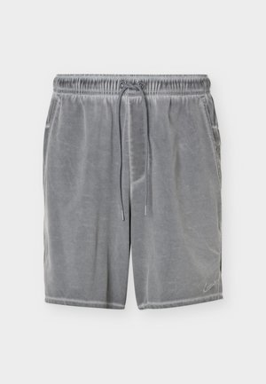 Shorts en velours gris avec taille élastique, cordon à l'avant, poches latérales et logo Nike discret sur la partie inférieure de la jambe gauche.