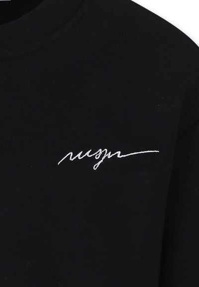 Zwarte lange mouwen shirt met witte cursieve borduursels op de borst. Gemaakt van een zachte stof met een gladde textuur.