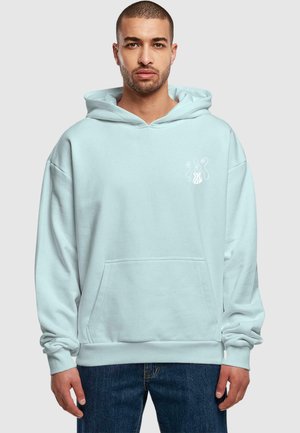 Light blue hoodie made of soft fabric with a kangaroo pocket, featuring white graphic design on the chest and ribbed cuffs.